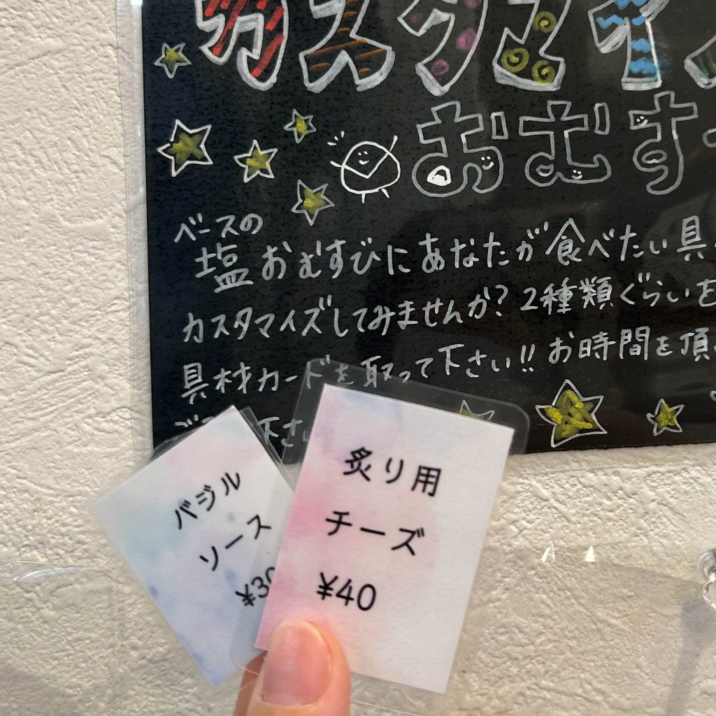 バジルソースと炙り用チーズの札を持つ様子
